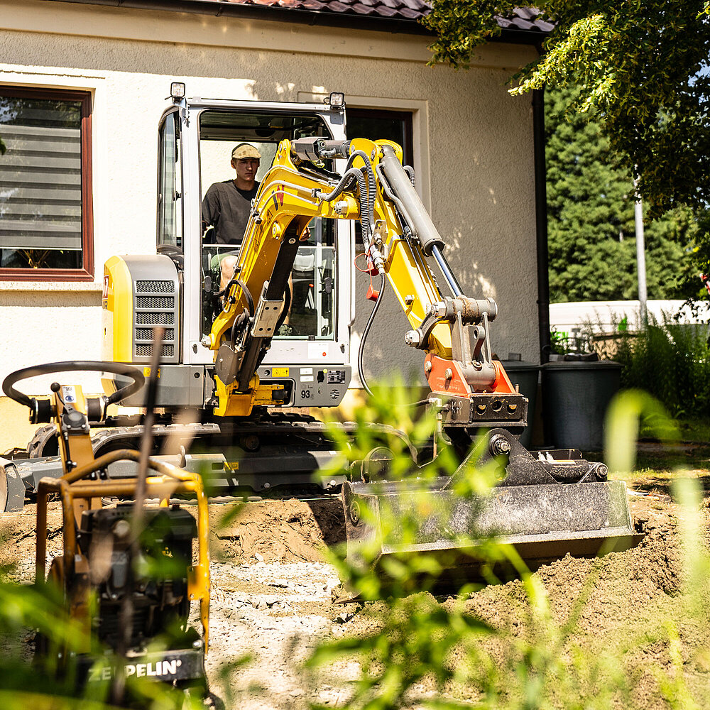 Paul verteilt Mutterboden mit dem Bagger